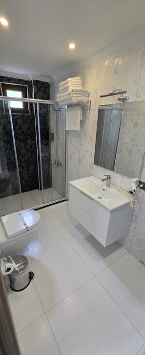 Quarto triplo luxo, sacada, vista parcial para o mar | Banheiro