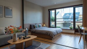 A modern bedroom with a large bed, a sofa, a coffee table, and a desk. - HoLo Giang Vo Hanoi - Serviced HomeStay (Hanoi)