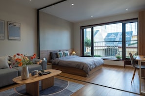 A modern bedroom with a large bed, a sofa, a coffee table, and a desk. - HoLo Giang Vo Hanoi - Serviced HomeStay (Hanoi)