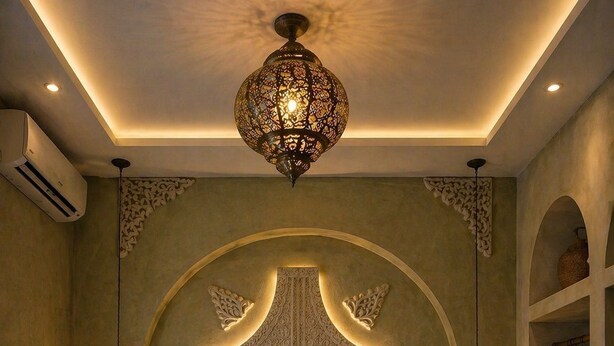 Un dormitorio con un diseño de pared en forma de cruz, dos lámparas de noche y almohadas con la etiqueta 'Riad Casa Saba'.