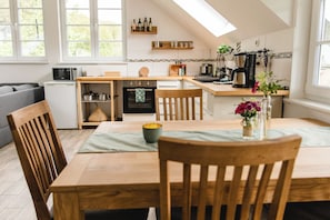 Eine moderne Küche mit Essbereich, eingebautem Ofen, Mikrowelle und Kaffeemaschine.
