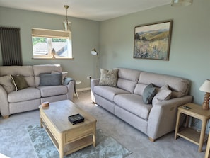 A living room with two sofas, a coffee table, a floor lamp, and a painting on the wall. - Thorn Tree Cottage (Hope Valley)
