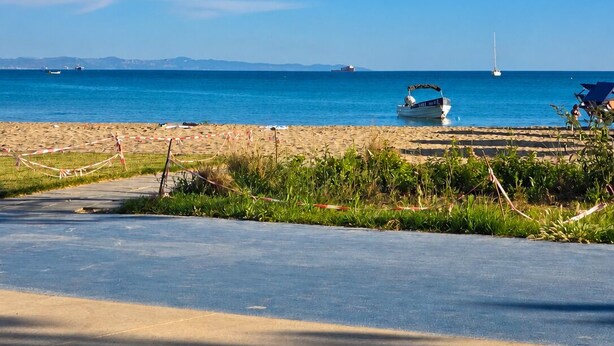 A beach with a clear sky, a sandy shore, and a road leading to the beach. - VOYYO SKYLINE (Durres)