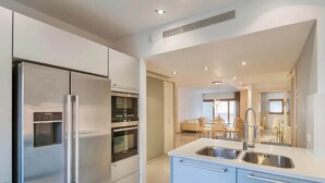 Una cocina moderna con refrigerador, horno y lavamanos incorporados.