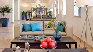 Un moderno hall de hotel con un sofá, una mesa de centro y plantas en macetas.