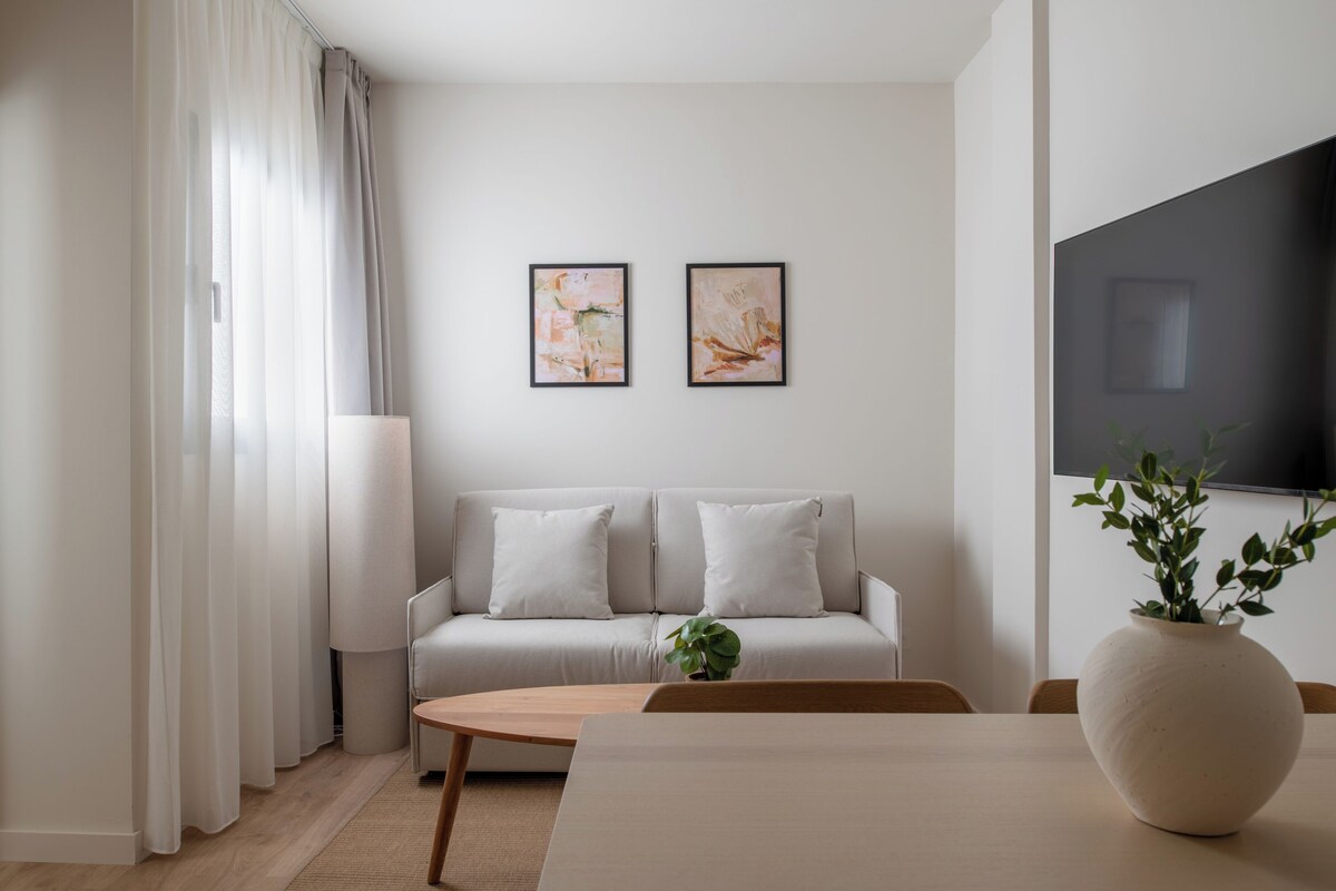 A modern living room with a sofa, a coffee table, and a TV.