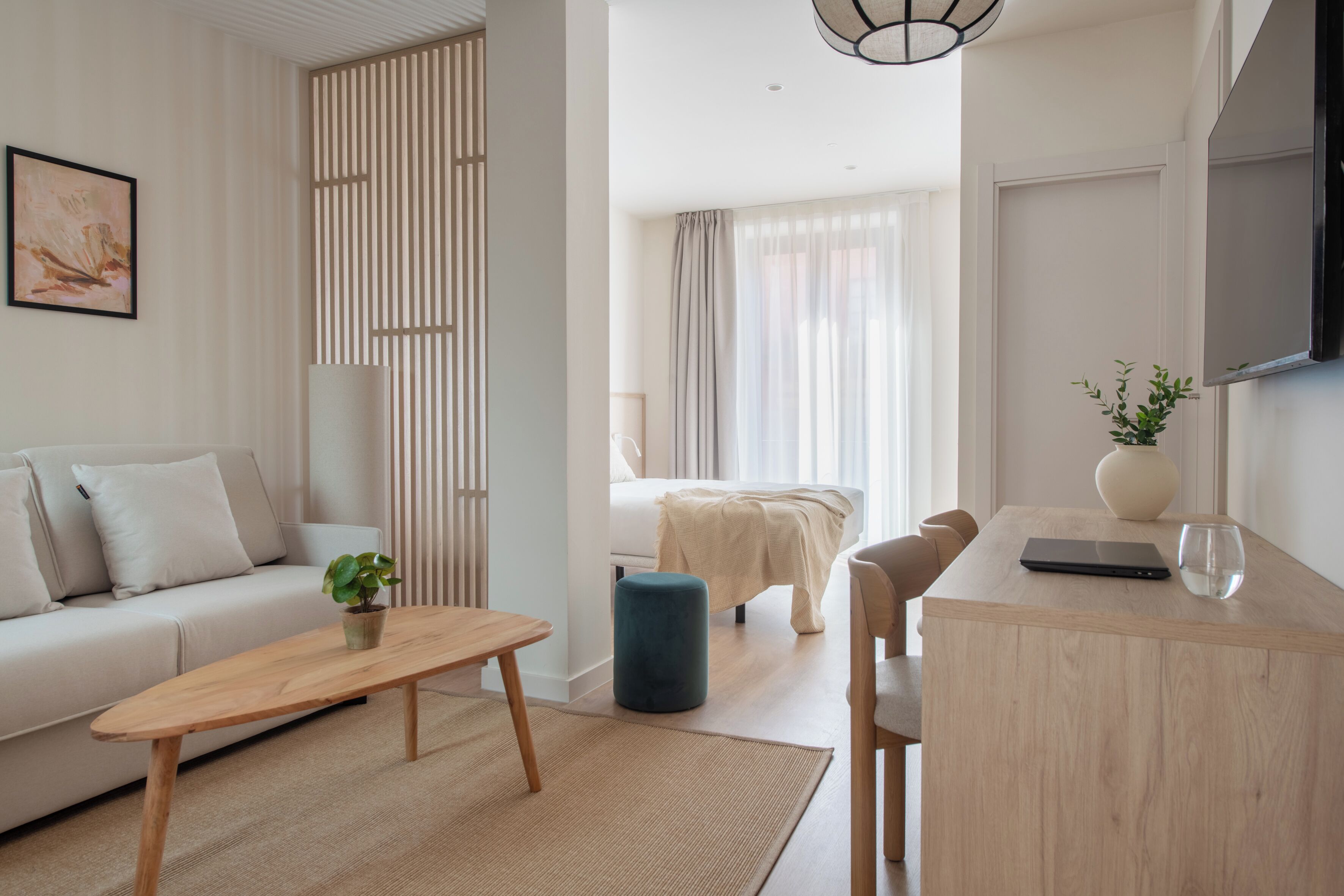 Un salon moderne comprenant un canapé, une table basse, un pouf et un coin repas avec une table et des chaises.