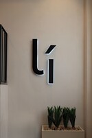 A wall-mounted sign with the letters 'Li' illuminated in black.