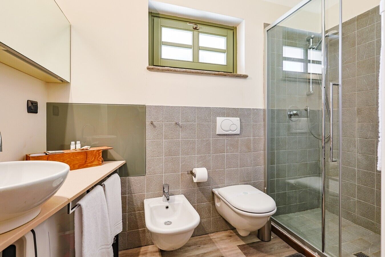 Une salle de bain équipée d’une douche, d’un bidet, d’un lavabo et d’une fenêtre.