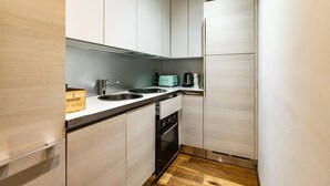 A compact kitchen with a sink, a toaster, and a refrigerator.