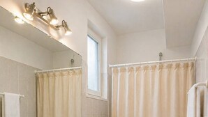 Un baño con lavamanos, inodoro y cortina de ducha.