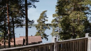 A view of a lake surrounded by tall trees and a building with a red roof. - Fagerudd (Enköping)