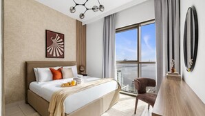 Ett modernt hotellrum med en stor säng, utsikt över staden, en matplats och en balkong.