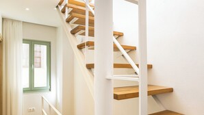 A staircase with wooden steps and white railings, leading to an upper floor. - CF Elegant Old Town Suite Fortezza View (Rethymno)