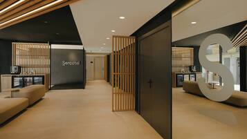 A modern hotel lobby with a reception desk, seating area, and a large S-shaped design element.