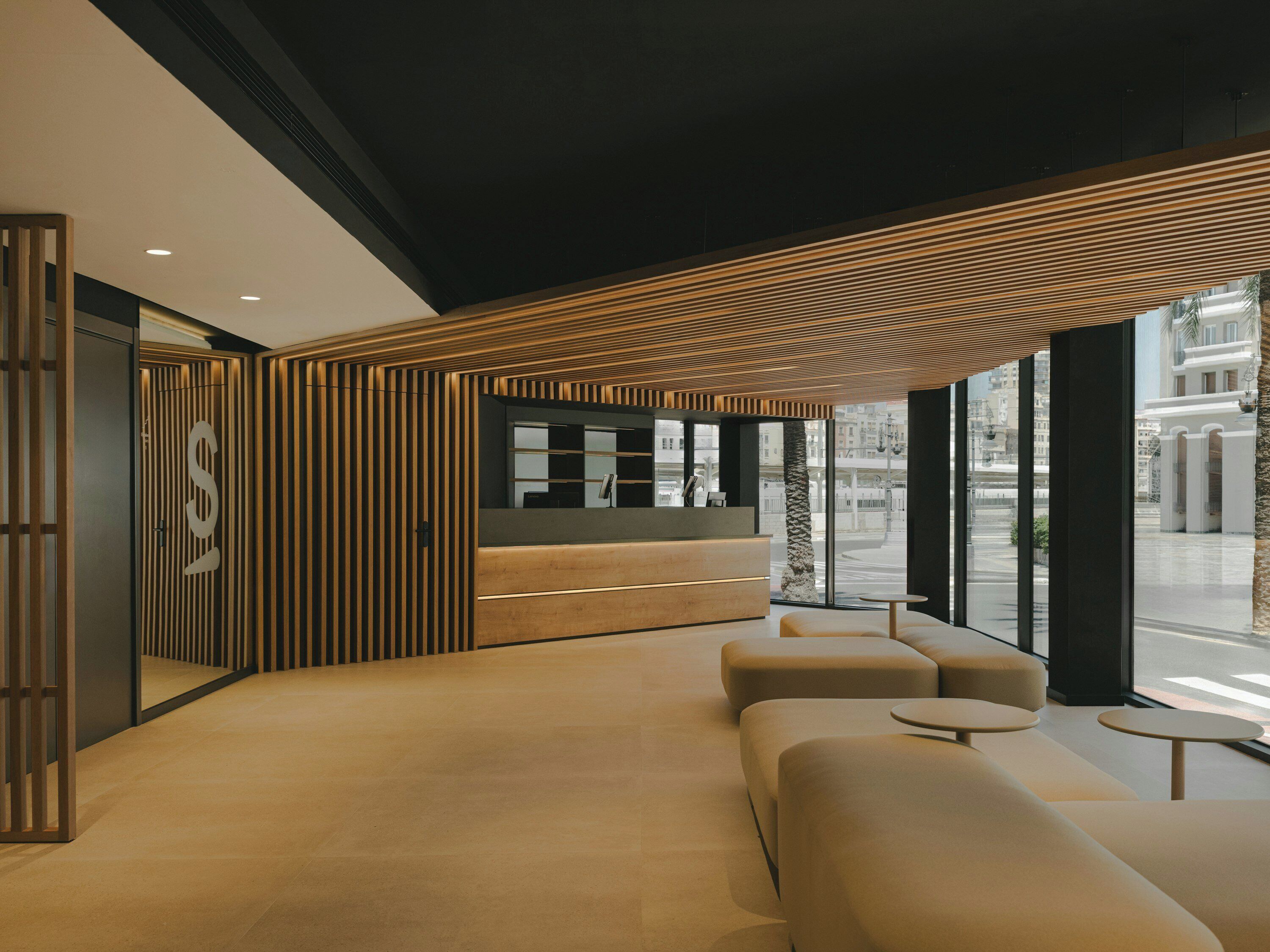 Un área de recepción moderna con techo de listones de madera, un mostrador de recepción y asientos.