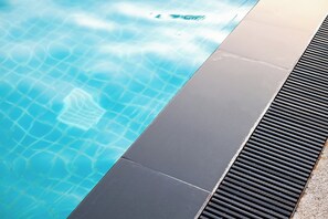 A swimming pool with clear water and a tiled edge.