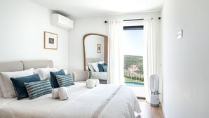 A bedroom with a large bed, a bedside table, a mirror, and a view of a pool. - Ericeira Wave Nest by Lisbeyond (Carvoeira)