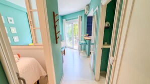 Un pasillo con una cama, un baño y una zona de cocina.