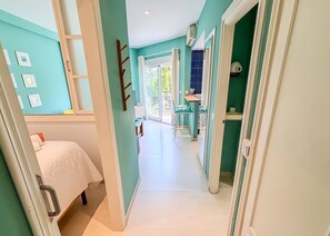 A hallway with a bed, a bathroom, and a kitchen area. - Skol 225 –  Beachfront studio in Marbella | Terrace & Pool (Marbella)