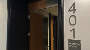 Hotellihuoneen ovi, jonka yläpuolella on kyltti, jossa lukee: ”401, ensiluokkainen huone”.