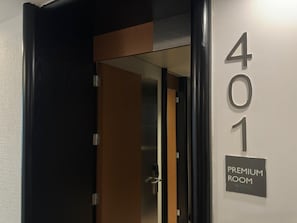 Entrada a una habitación de hotel, con una puerta que indica '401 PREMIUM ROOM'.