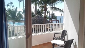 A balcony with a view of a pool and palm trees. - Apartment in Albatros Club Resort, Juan Dolio (Playa Juan Dolio)