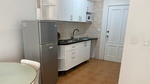 A compact kitchen with a refrigerator, sink, and cabinets. - Apartment in Albatros Club Resort, Juan Dolio (Playa Juan Dolio)