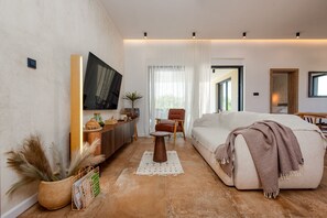A modern living room with a sofa, a coffee table, a TV, and a dining area. - Villa D  Briševo ZadarVillas (Briševo)