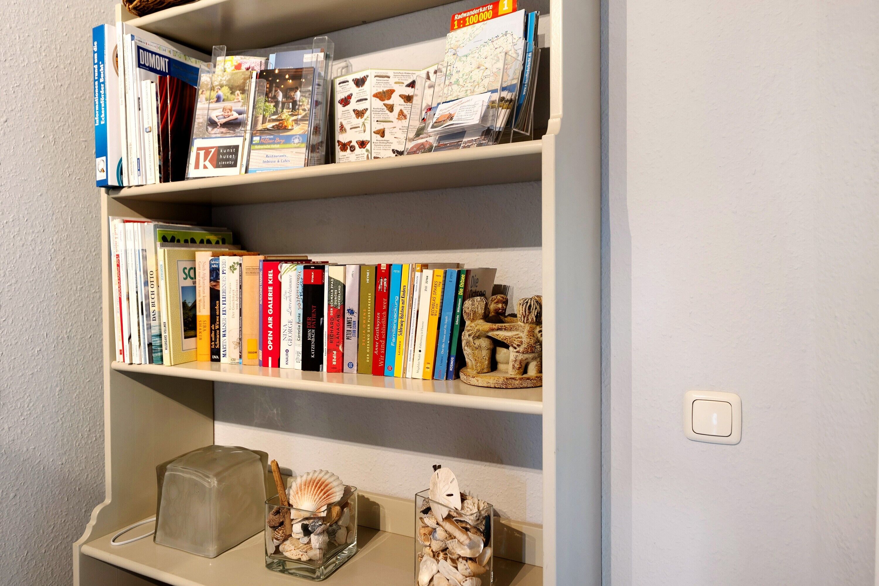 A bookshelf with various books and decorative items.