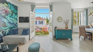 A modern living room with a sofa, a dining table, and a view of a courtyard. - Renovated T3 in Mourillon with balcony - Beaches on foot, premium location in Toulon (Toulon)
