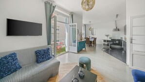 A modern living room with a sofa, a coffee table, and a TV mounted on the wall. - Renovated T3 in Mourillon with balcony - Beaches on foot, premium location in Toulon (Toulon)