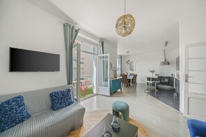 A modern living room with a sofa, a coffee table, and a TV mounted on the wall. - Renovated T3 in Mourillon with balcony - Beaches on foot, premium location in Toulon (Toulon)