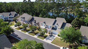 A residential neighborhood with houses, a street, and a lake in the background. - 3-B/R Townhome with Garage Murrells Inlet, The Clubhouse Retreat 
Near TPC (Murrells Inlet)