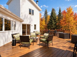 Terraza con mobiliario exterior y vista a una casa blanca.