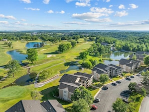 Ein Golfplatz mit Clubhaus, Parkplatz und Wohnhäusern.