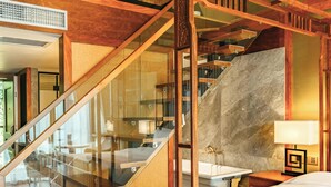 A four-poster bed with a marble wall and a wooden staircase. - Manshe Creek Garden Boutique Resort  (Hangzhou)