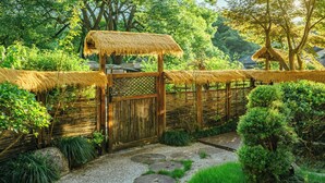 A traditional Japanese garden with a wooden gate, thatched structures, and well-maintained greenery. - Manshe Creek Garden Boutique Resort  (Hangzhou)