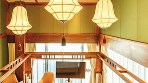A room with a wooden staircase, two leather armchairs, a wooden coffee table, and three hanging lamps. - Manshe Creek Garden Boutique Resort  (Hangzhou)