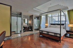 A modern hotel room with a four-poster bed, a walk-in closet, and a large window with curtains.