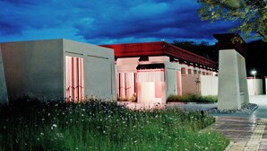 A modern building with a red roof, large windows, and a well-maintained garden area. - Shigatse Summer Palace Healing Hotel (Shigatse)