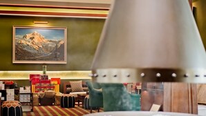 A hotel lobby with a mountain painting, a lamp, and a table with a white cloth. - Shigatse Summer Palace Healing Hotel (Shigatse)