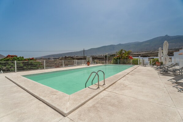 A rooftop pool with a clear view of mountains in the background.