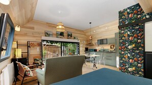 A room with a bed, a chair, a table, a window, and a kitchen area. - Maison “Gîte Mimosas” with Terrace and Wi-Fi (Marzan)