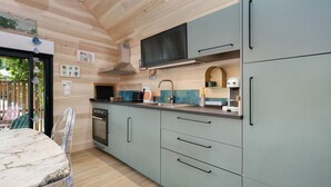 A kitchen with a wooden ceiling, a sink, a stove, and a dining area with a table and chairs. - Maison “Gîte Mimosas” with Terrace and Wi-Fi (Marzan)