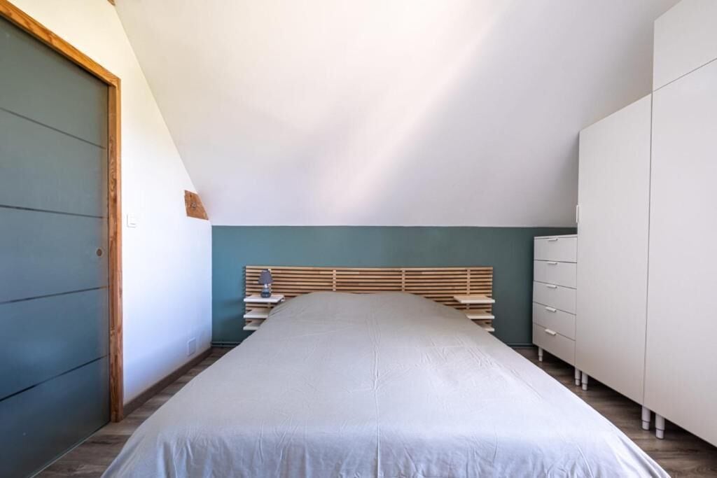 Un dormitori amb llit, una tauleta de nit, un armari i un guarda-roba.