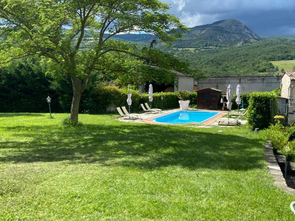 Una piscina al aire libre de temporada, sombrillas, tumbonas