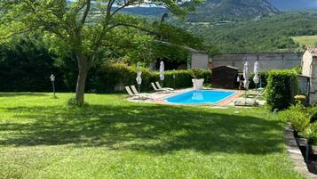 Una piscina al aire libre de temporada, sombrillas, tumbonas