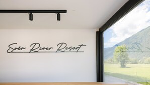 Un mur sur lequel on peut lire les mots « Soda River Resort », et une fenêtre donnant sur une montagne et la verdure.