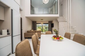 Eine moderne Küche mit Essbereich, einer Treppe und Blick ins Freie.